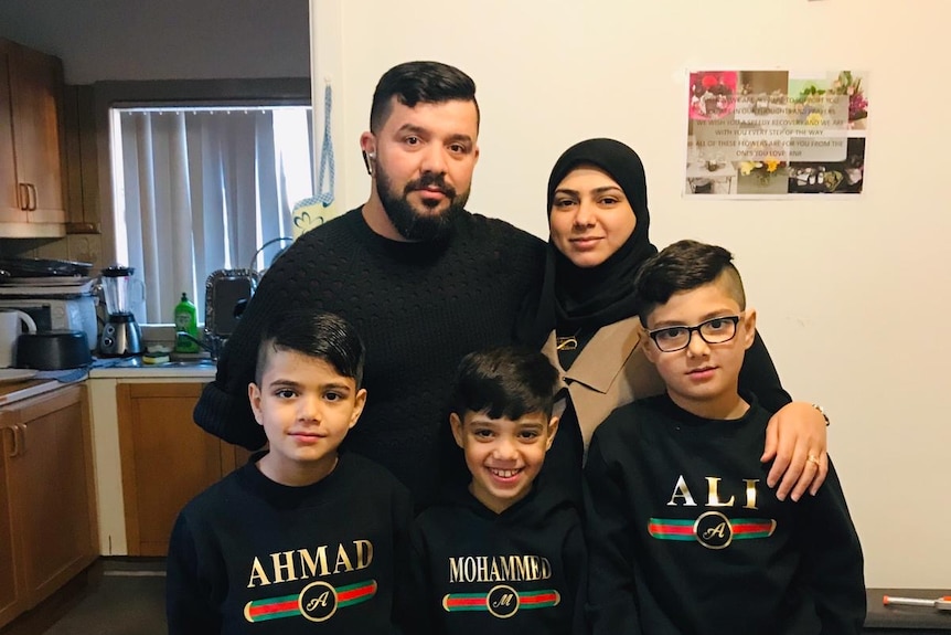 A photograph of a man with a beard, his wife and three boys