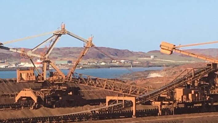 Looking over Rio Tinto iron ore stockpiles on Burrup Peninsular, near Dampier, WA. Cranes, reclaimers, ocean in distance