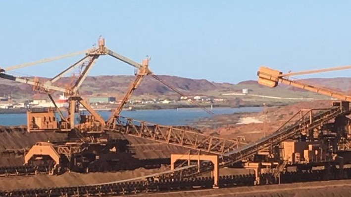 Looking over Rio Tinto iron ore stockpiles on Burrup Peninsular, near Dampier, WA. Cranes, reclaimers, ocean in distance