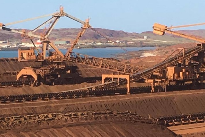 Looking over Rio Tinto iron ore stockpiles on Burrup Peninsular, near Dampier, WA. Cranes, reclaimers, ocean in distance