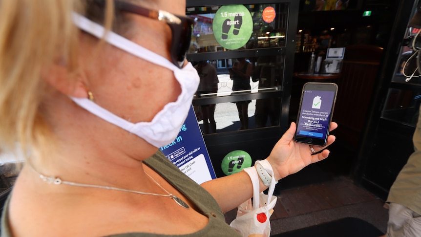 A woman uses the Territory Check In app to enter a venue.
