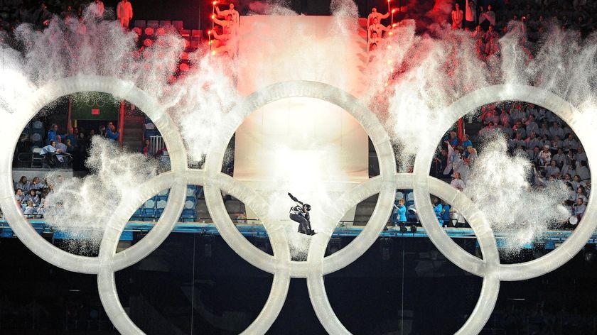 Let the Games begin ... A snowboarder jumps through the Olympic rings.