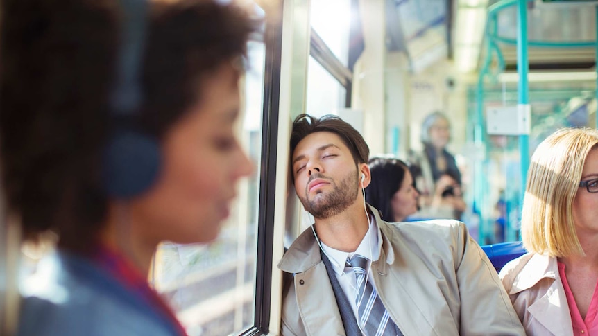 A man napping on the train on the way to work.