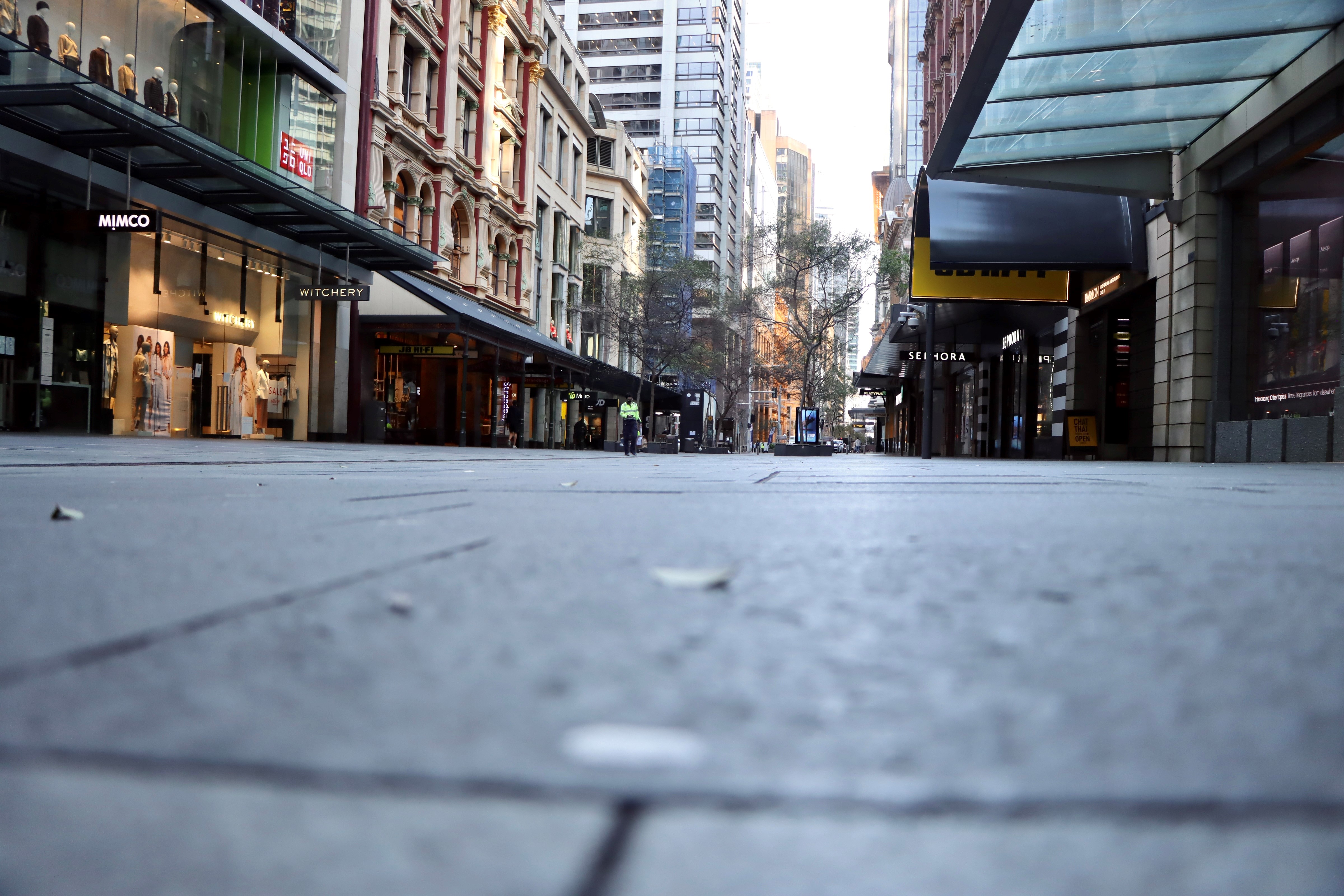 悉尼 CBD 空荡荡的零售地带，沿着人行道从低处拍摄的艺术照片。” class=