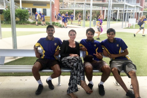 Bridget Brennan sits on a bench with year 12 students at their school.