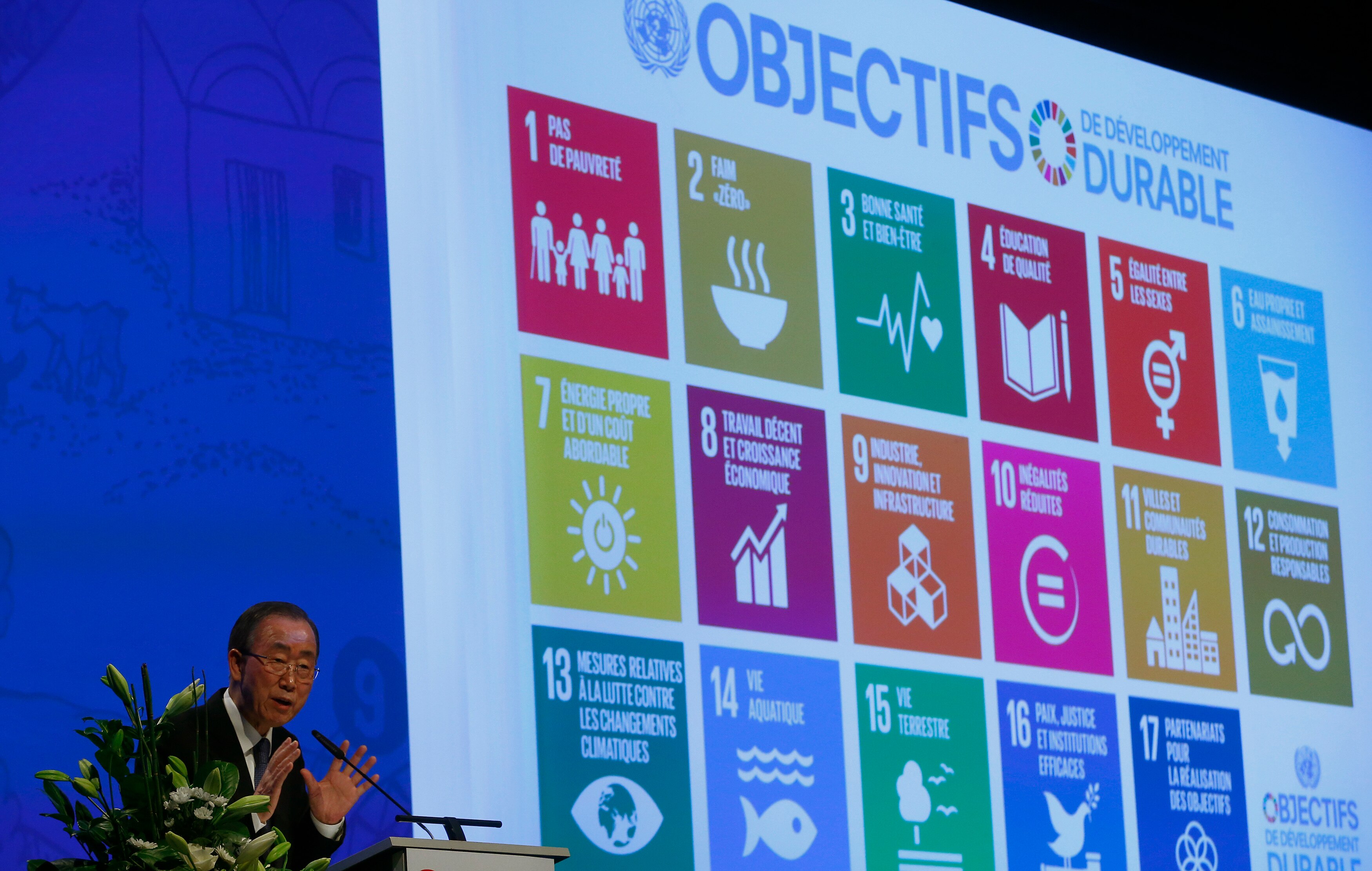 Ban Ki Moon speaks at a podium as a screen behind him displays the UN's SDGs.