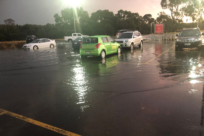 A flooded car park at dusk.