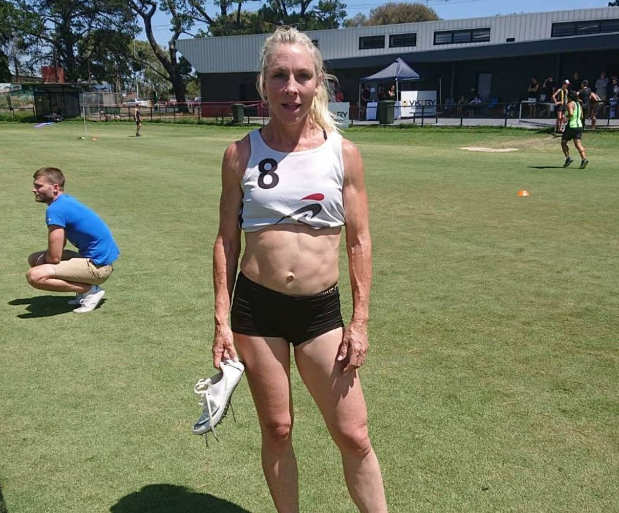A woman in running gear looks straight at the camera.