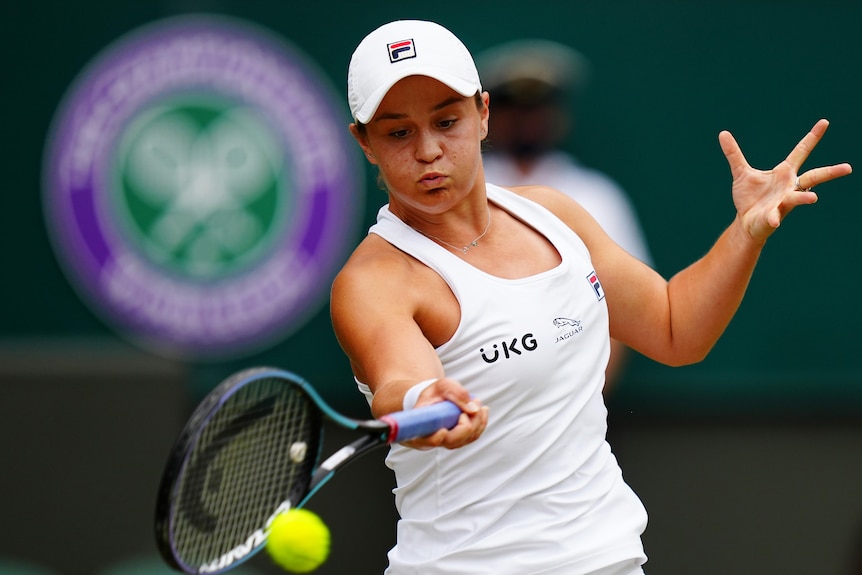 An Australian female tennis players uses a forehand during her Wimbledon semi-final.