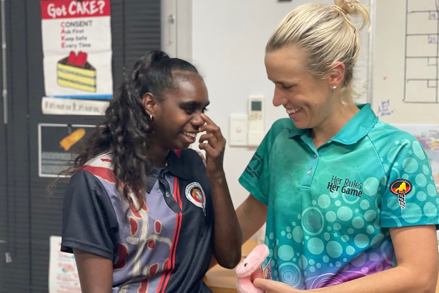 An Indigenous girl and a nurse share a laugh in an office
