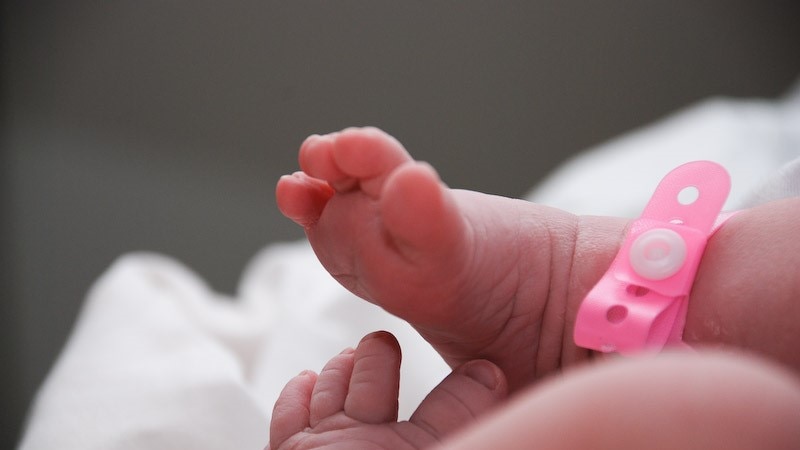 A baby girl's feet with an identification bracelet.