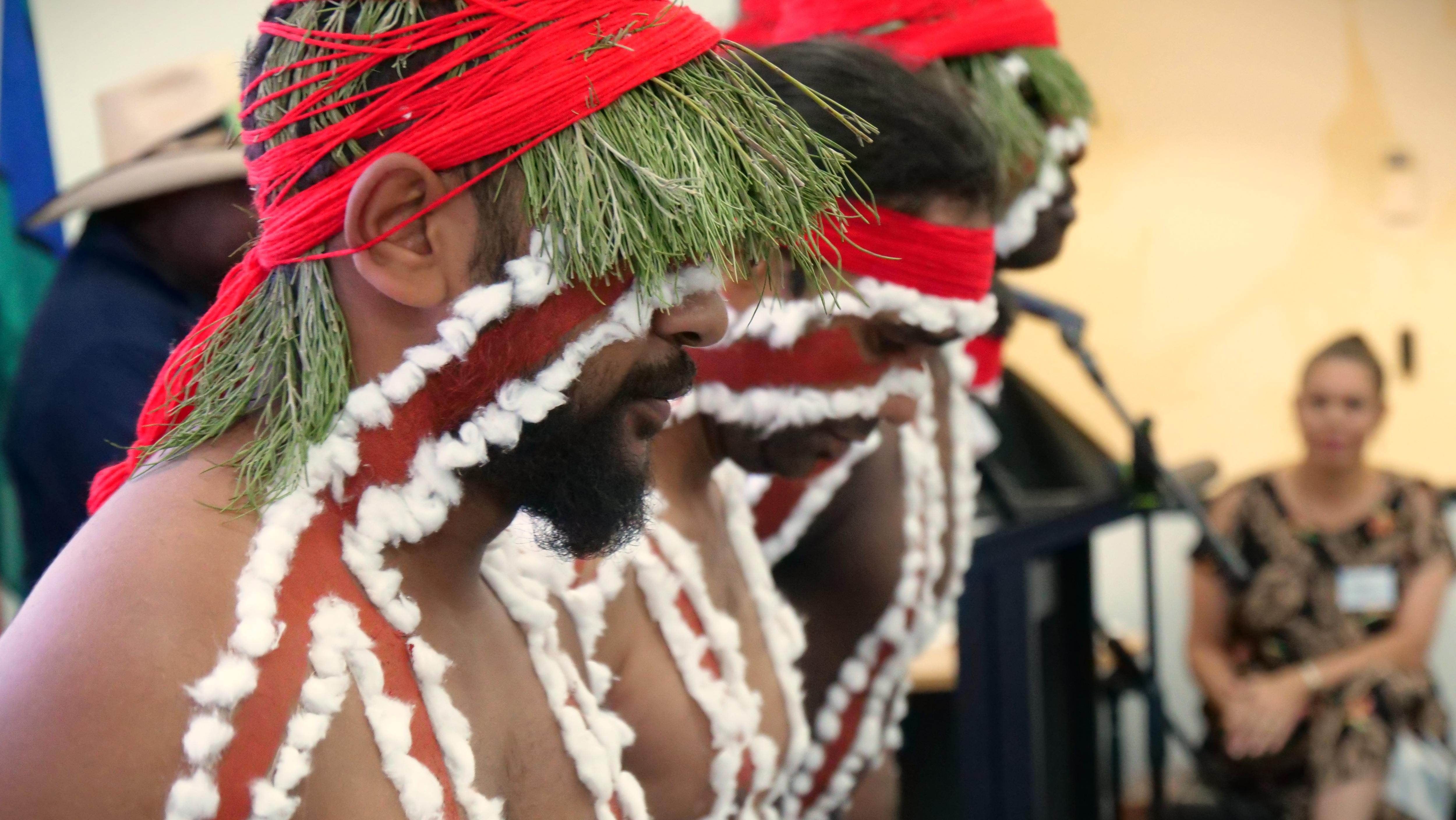 Three men in traditional Indigenous clothing