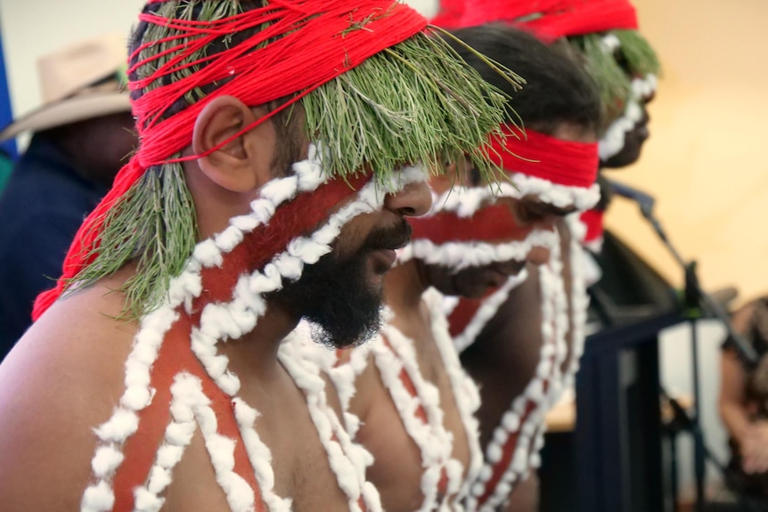 Three men in traditional Indigenous clothing