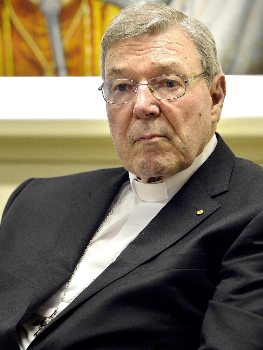 Upper body photo of Cardinal George Pell, sitting and listening.