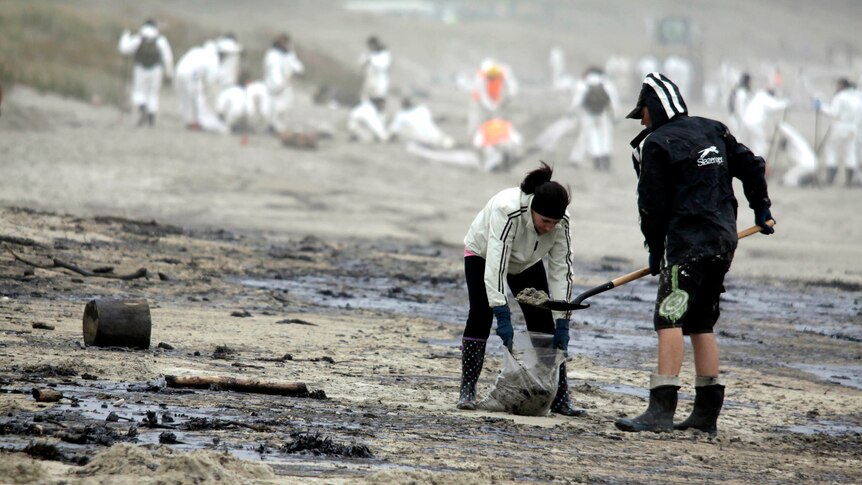 Volunteers clean-up oil on Papamoa beach