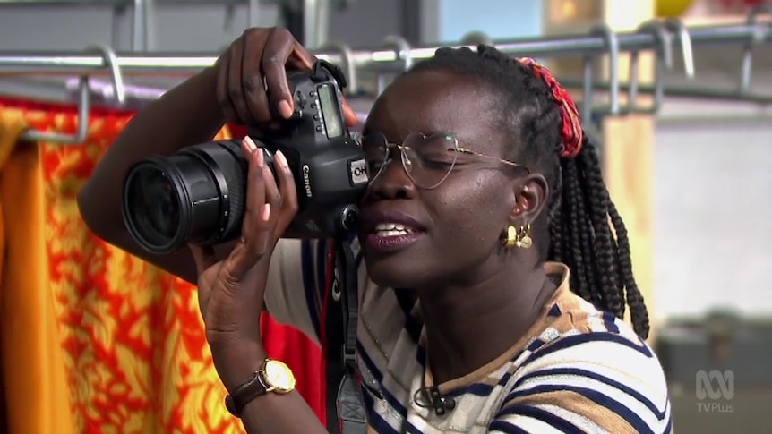 Photographer Atong Atem holds camera up ready to take photo