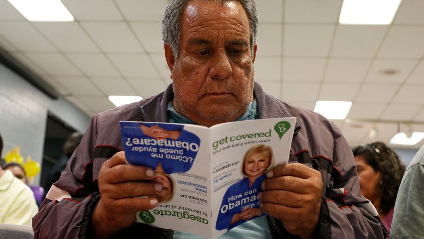Jesus Dominguez reads a pamphlet at a health insurance enrolment event in California