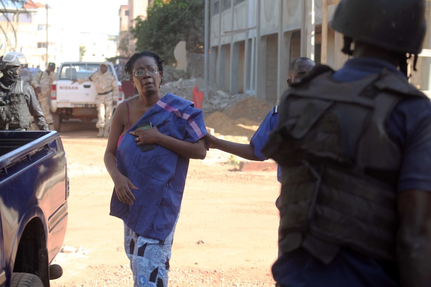 A woman runs away from the Radisson Blu hotel