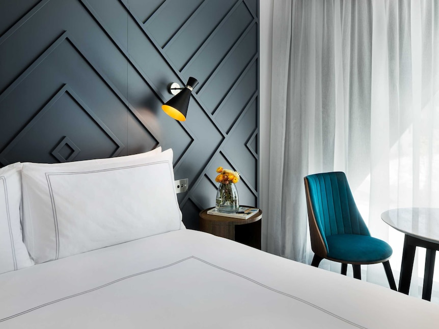 Bed and lamp in room at the West Hotel in Sydney's Barangaroo district.