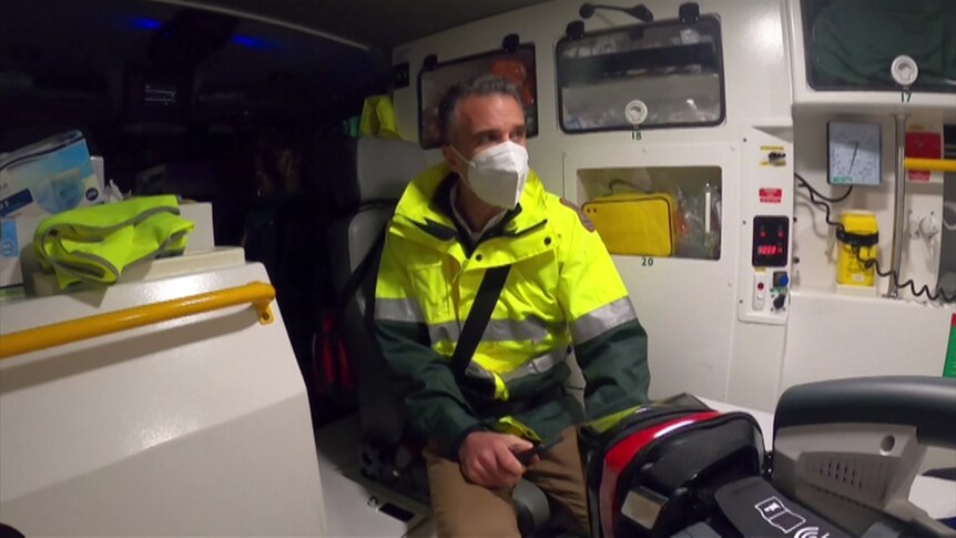 Man in back of ambulance with mask on