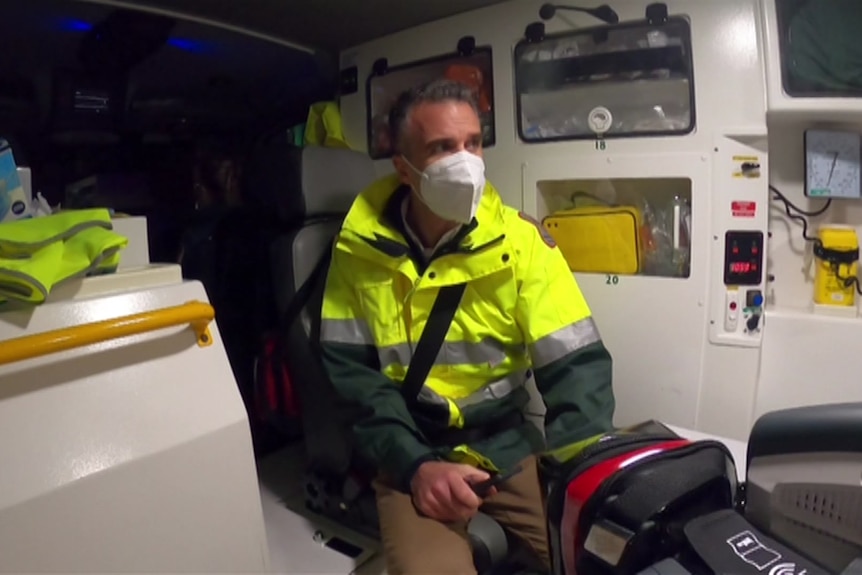 Man in back of ambulance with mask on