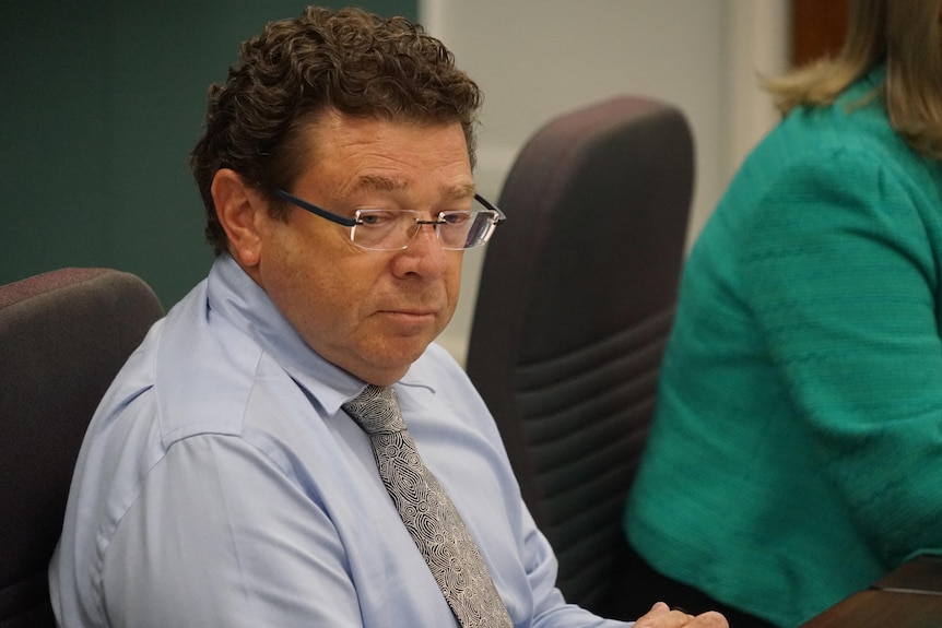Shaun Drabsch sits behind a desk at NT parliamentary hearings.