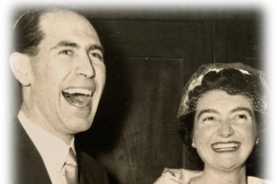 Black and white photo of Ron Haddrick and wife wearing evening wear and smiling at camera.