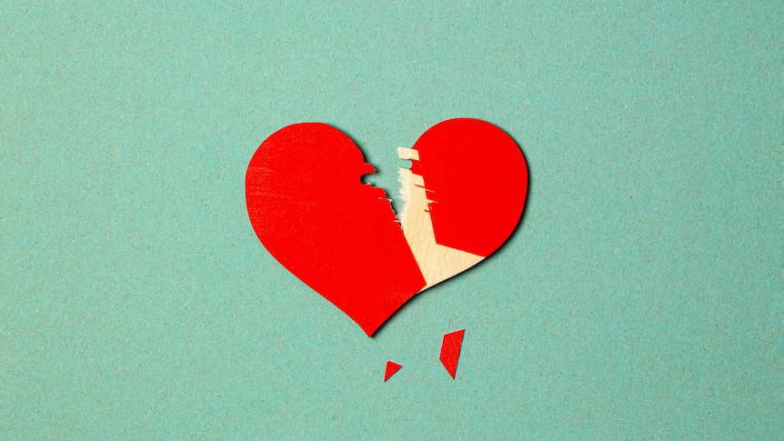 A partially chipped red heart sits on a green background