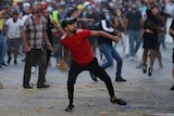 People throw stones during anti-government protest following Tuesday's massive explosion which devastated Beirut.