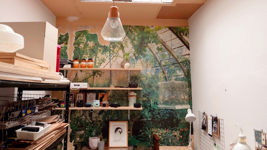 Office with skylight, desks and tattered photographic mural on far wall.