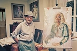 Australian artist Arthur Murch in his studio, standing next to a portrait of Rubina Namatjira on an easel
