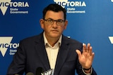 Daniel Andrews gestures with is left hand at a press conference.