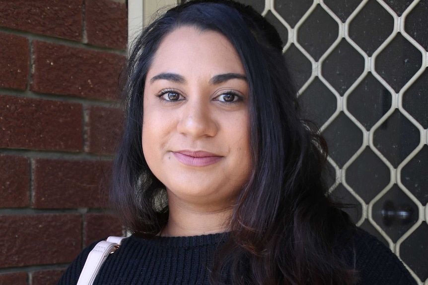 A headshot of a woman outside her front door.