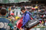 Frustrating day ... Novak Djokovic leaves the court during a rain delay