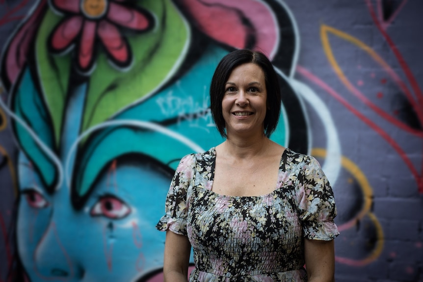 Business mentor, Anna Heaton, standing in front of a wall smiling to the camera.