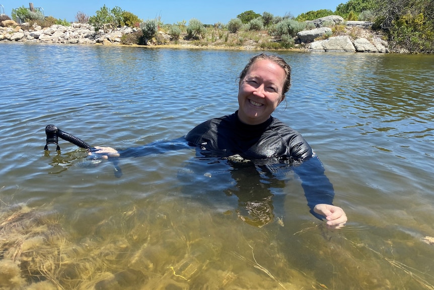 An environmental scientist dives into the Kourou River.