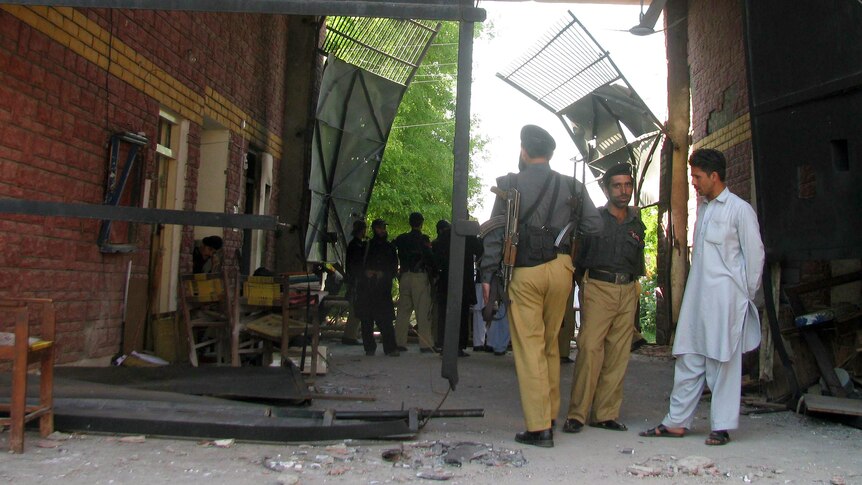 Militants escape ... Pakistani security officials gather at the damaged main entrance of the prison.