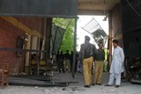 Militants escape ... Pakistani security officials gather at the damaged main entrance of the prison.