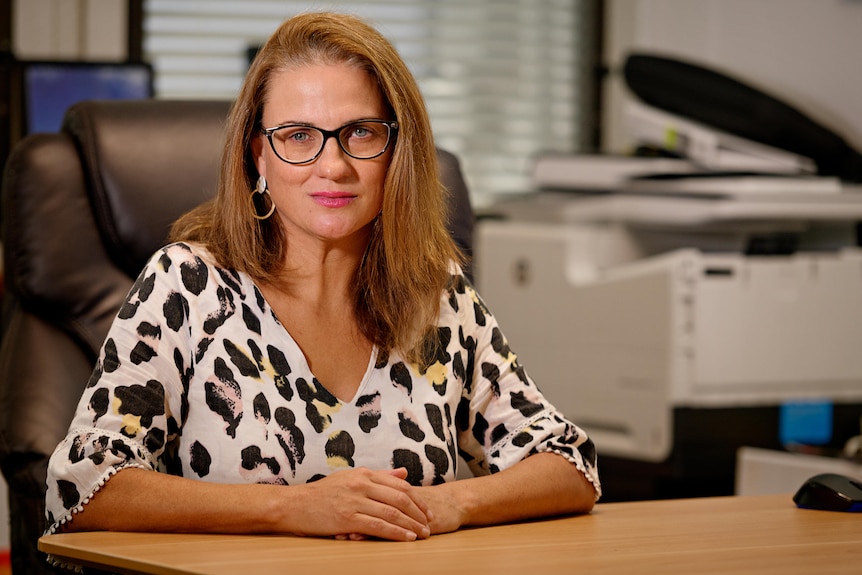 A woman sits in her office. 