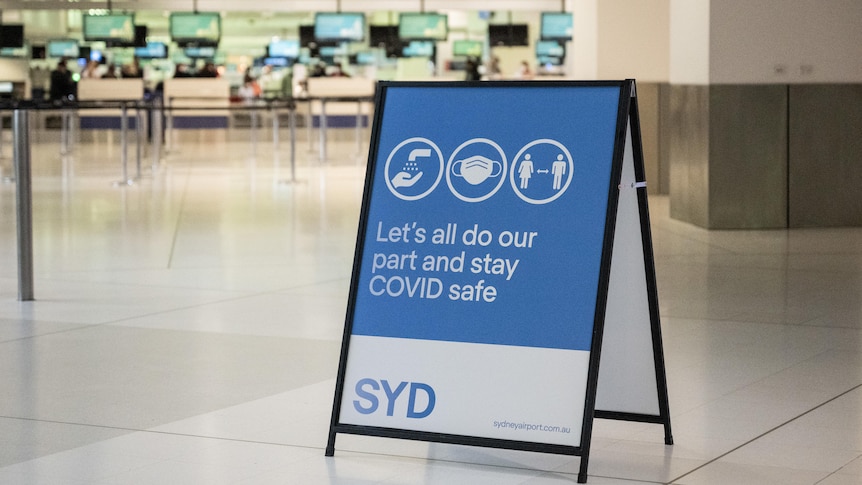 a signage about covid safe procedures in the middle an empty airport