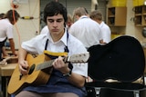 Sacred Heart College student plays new guitar