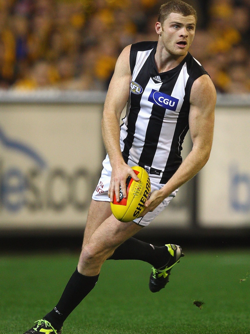 Collingwood player Heath Shaw kicks during an AFL match.