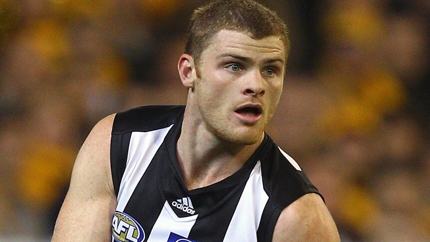 Collingwood player Heath Shaw kicks during an AFL match.