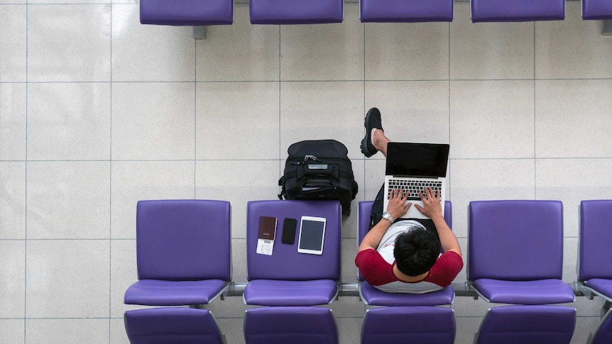 Aerial view of man working on laptop at an airport.