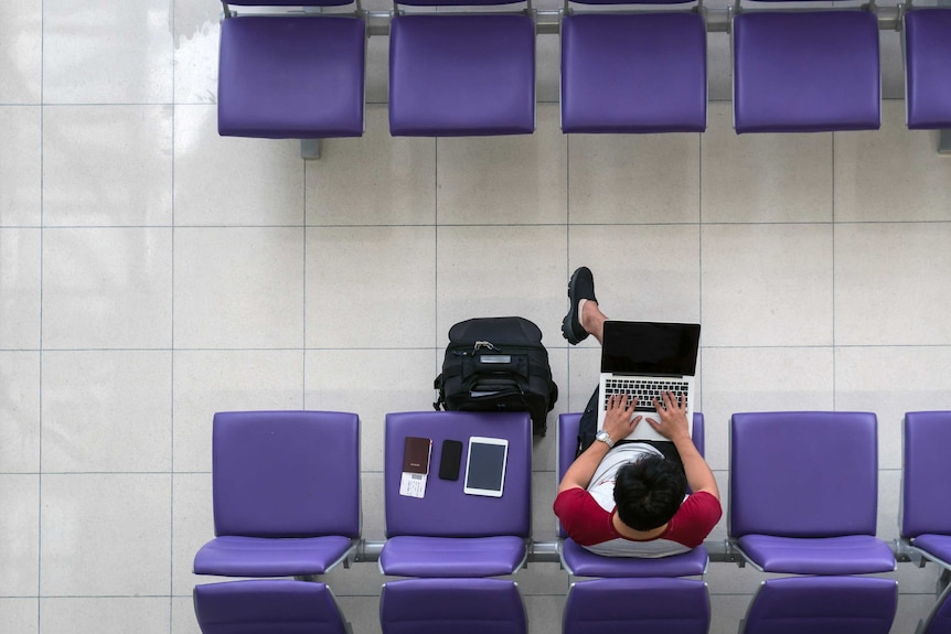 Aerial view of man working on laptop at an airport.