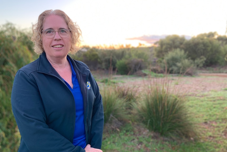 a woman standing near some bushland