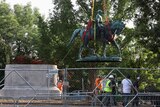 Workers remove a statue of Confederate General Robert E Lee