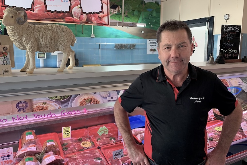Dean Hinds stands in front of his butcher counter.
