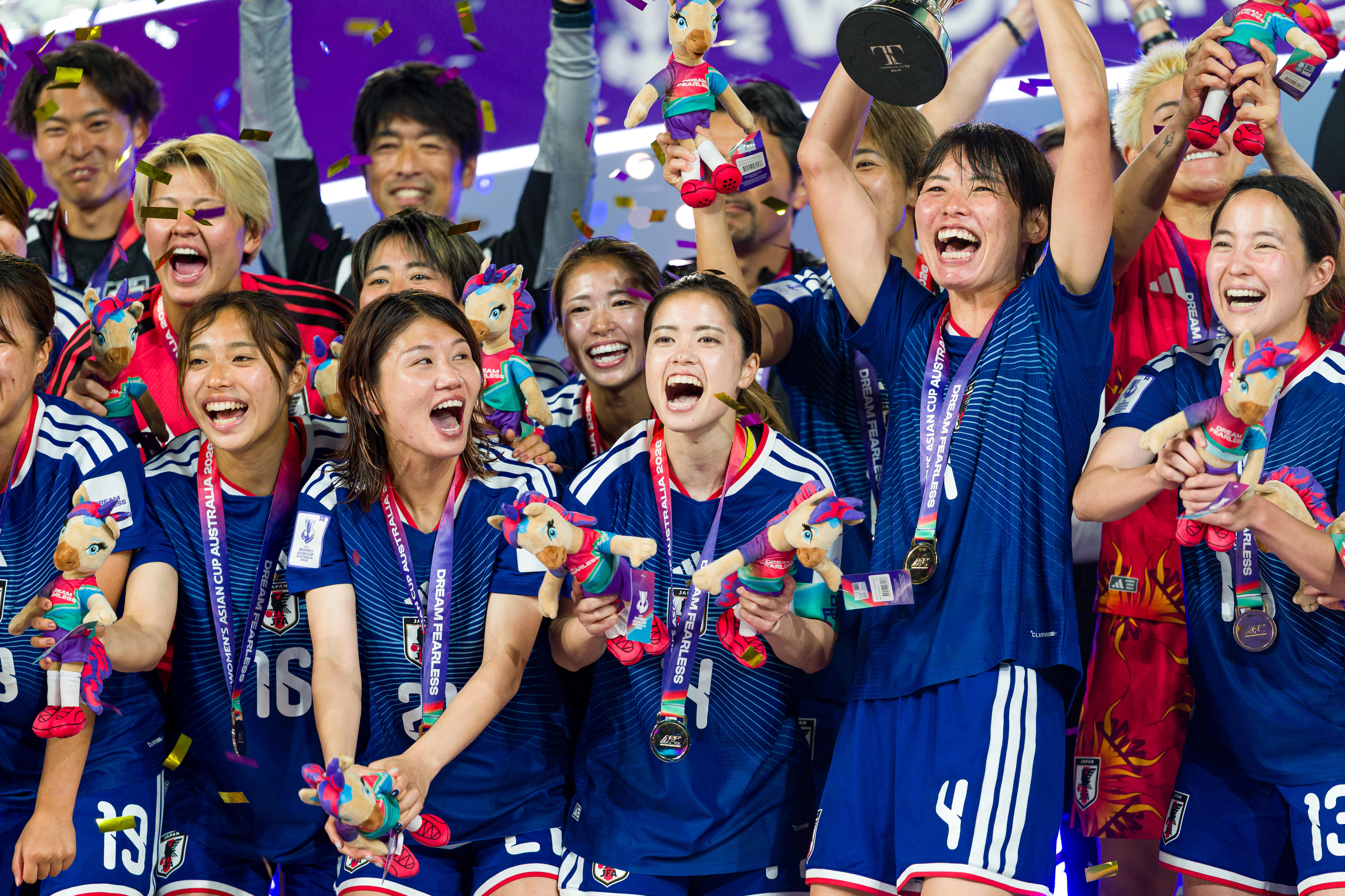 Membros da seleção japonesa de futebol feminino comemoram a posse do troféu da Copa da Ásia