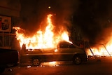 A van set on fire by protesters burns in Santiago.